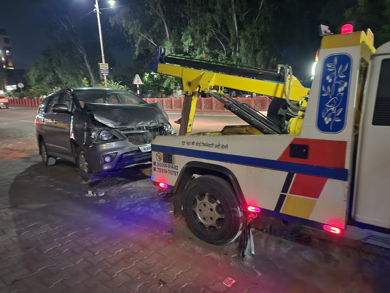 Recovery truck assisting a damaged car at night